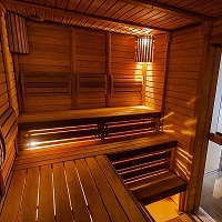 Inside view of a medium sized wooden infra red sauna with the lights turned on