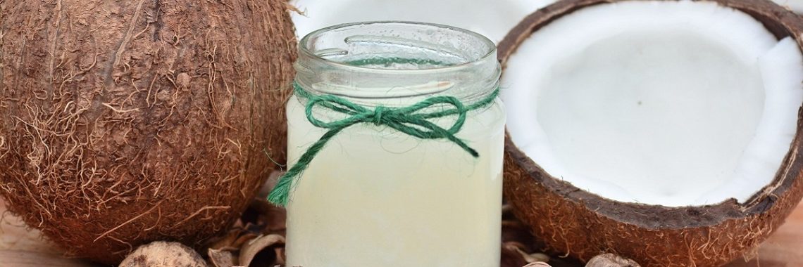 Jar of coconut oil with open fresh coconut next to it