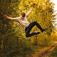 Young man leaping happily in the air in a forest