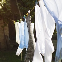 Natural fibre shirts and socks drying in the sun on a washing line