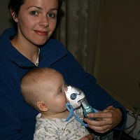 Woman nursing her baby and holding a ventillator to its face