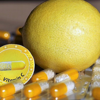 Vitamin C capsules with a lemon in the background