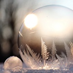 Soap bubble in the sunshine with ice crystals growing on it.