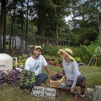 Healthy couple in their vegetable garden, with a sign that says 'Love food, Live body.'